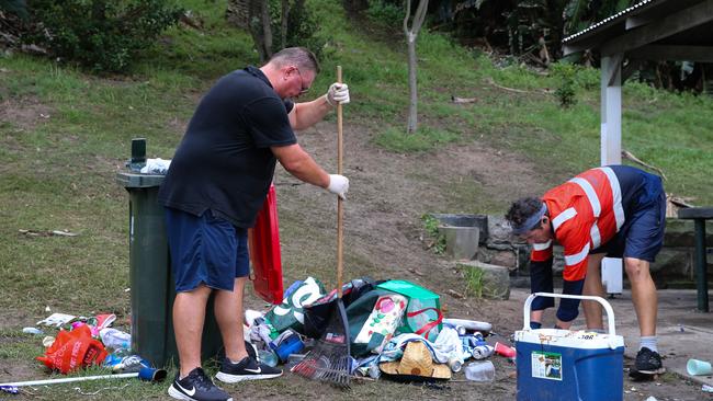 Bronte Beach resident Robert Kokolich helps a council worker clean up the enormous amount of rubbish and broken glass left behind from Christmas Day celebrations. Picture: NCA NewsWire / Gaye Gerard