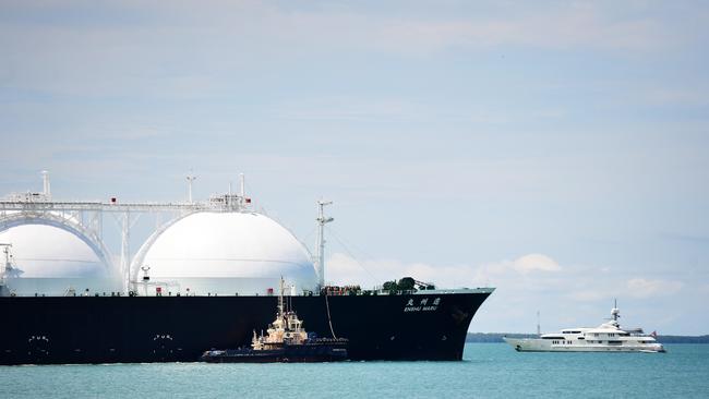 A massive cargo ship with natural gas dwarfs a yacht in the Darwin Harbour as it departs from the Ichthys LNG Project at its onshore gas liquefaction plant in Darwin on Friday morning.Picture: Justin Kennedy