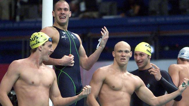 Chris Fydler, Ashley Callus, Michael Klim and Ian Thorpe play air guitar after defeating the USA in the men's 4x100 freestyle relay final at the Sydney Olympics