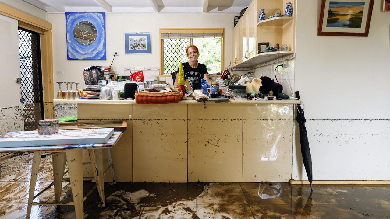 Mellissa Trommestad stands in her flooded home at Holloways Beach. She had moved as many of her possessions as possible onto her kitchen bench, the highest point of her lowset home. Picture: Brendan Radke