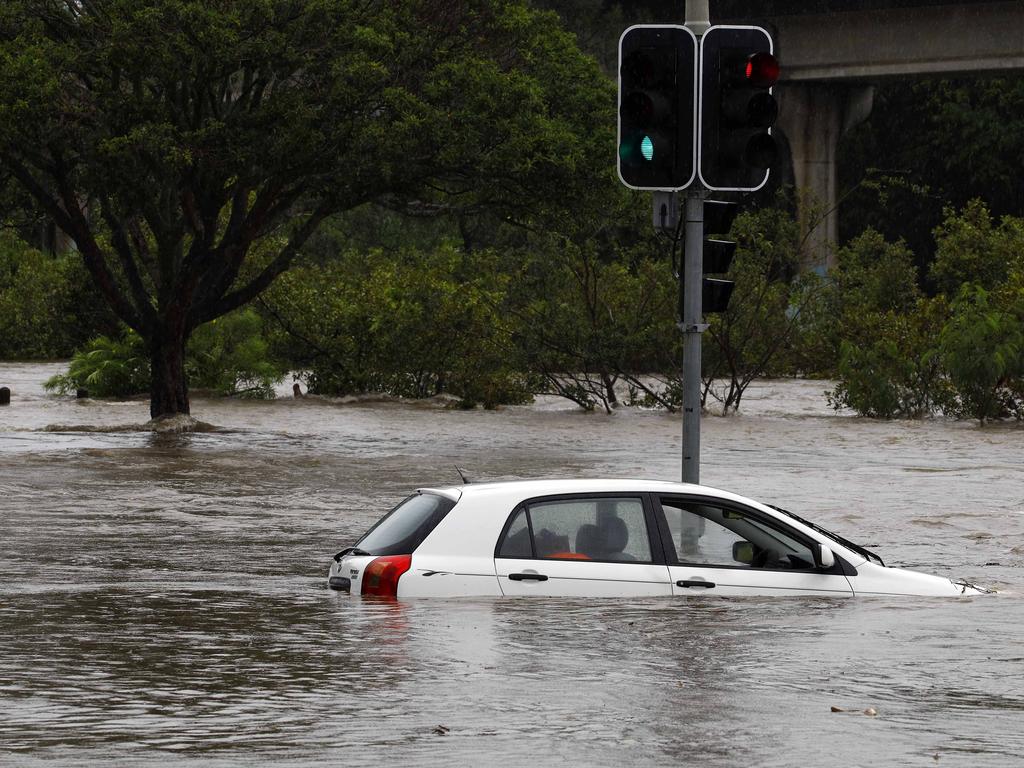 A car is stuck in flood waters in Toombul after heavy rain fell overnight in Brisbane. Picture: Tertius Pickard