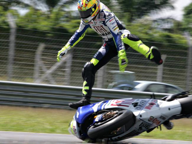 Valentino Rossi is thrown off his bike following a crash. Picture: AFP PHOTO/SHUKOR JANIS