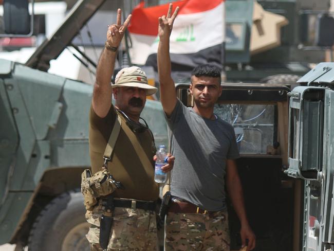 Iraqi government forces flash the V for victory sign in Fallujah after they took the embattled city. Picture: Haidar Mohammed Ali