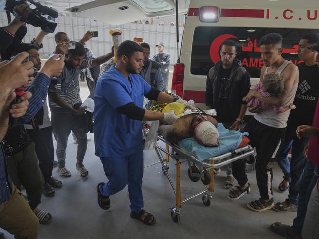 A wounded man and a child are taken into the Nasser hospital after an Israeli army strike hit a house killing at least five members of the Abu Sahloul family in the southern Gaza Strip. Picture: AP