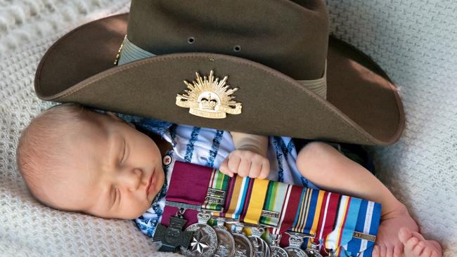 Baby Jack Keighran with the slouch hat and medals of his dad Daniel Keighran.