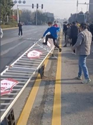 Workers at Foxconn's iPhone factory in Zhengzhou in central China breaking down a fence. Photo by AFPTV teams.