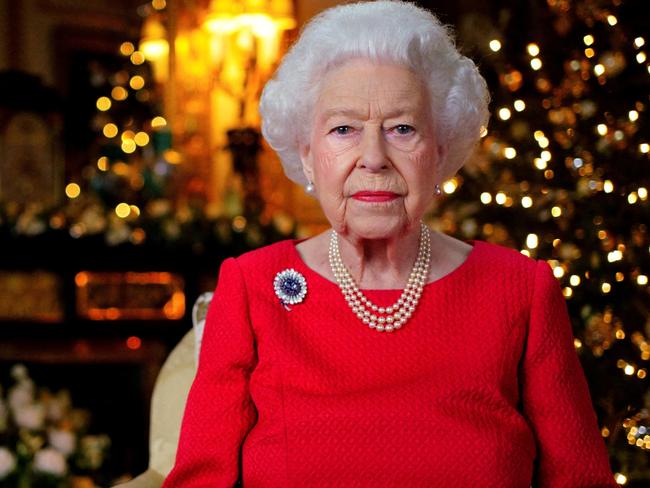 Britain's Queen Elizabeth records her annual Christmas broadcast in the White Drawing Room in Windsor Castle, next to a photograph of the queen and the Duke of Edinburgh, in Windsor, Britain, December 23, 2021. Victoria Jones/Pool via REUTERS