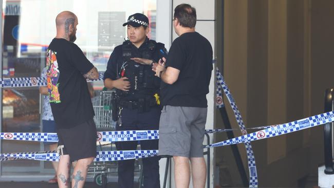 Police talk to locals at the scene on Sunday. Picture Lachie Millard