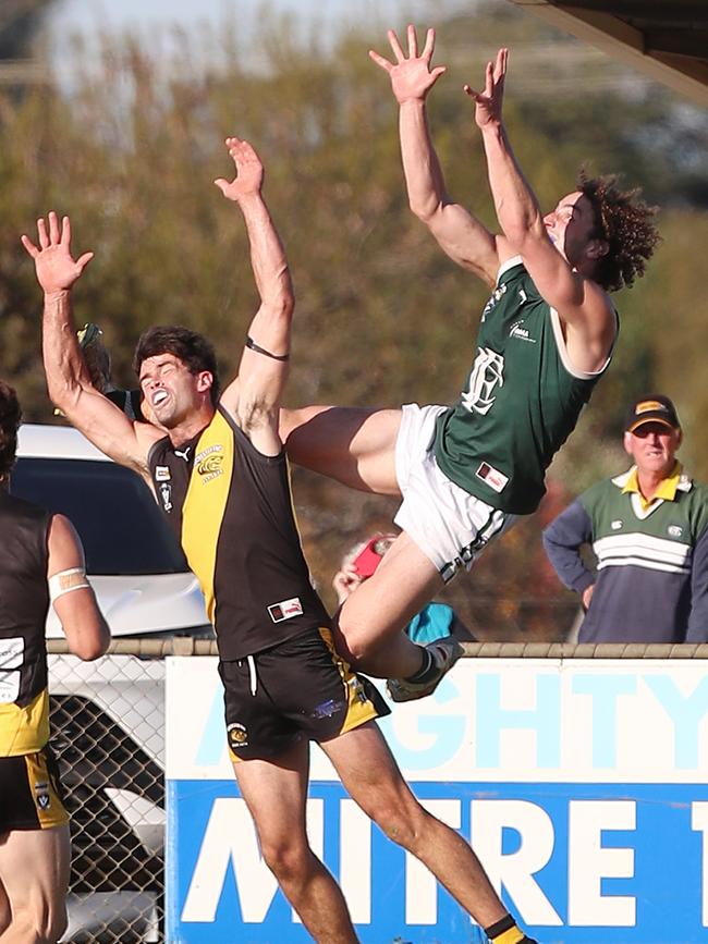 Echuca’s Liam Tenace takes a ride on Rochester’s Lachlan Watson.