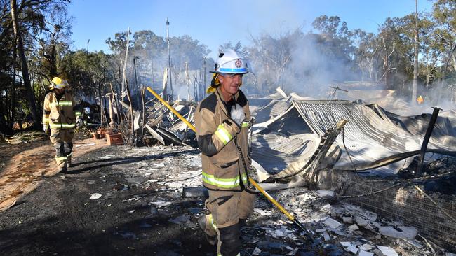 Firemen look over the remains at Noosa North Shore. Picture: AAP/Darren England