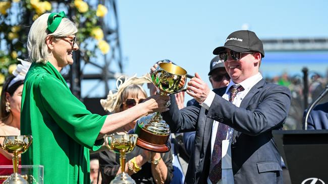 Cameron Bain takes the Melbourne Cup from Governor-General Sam Mostyn