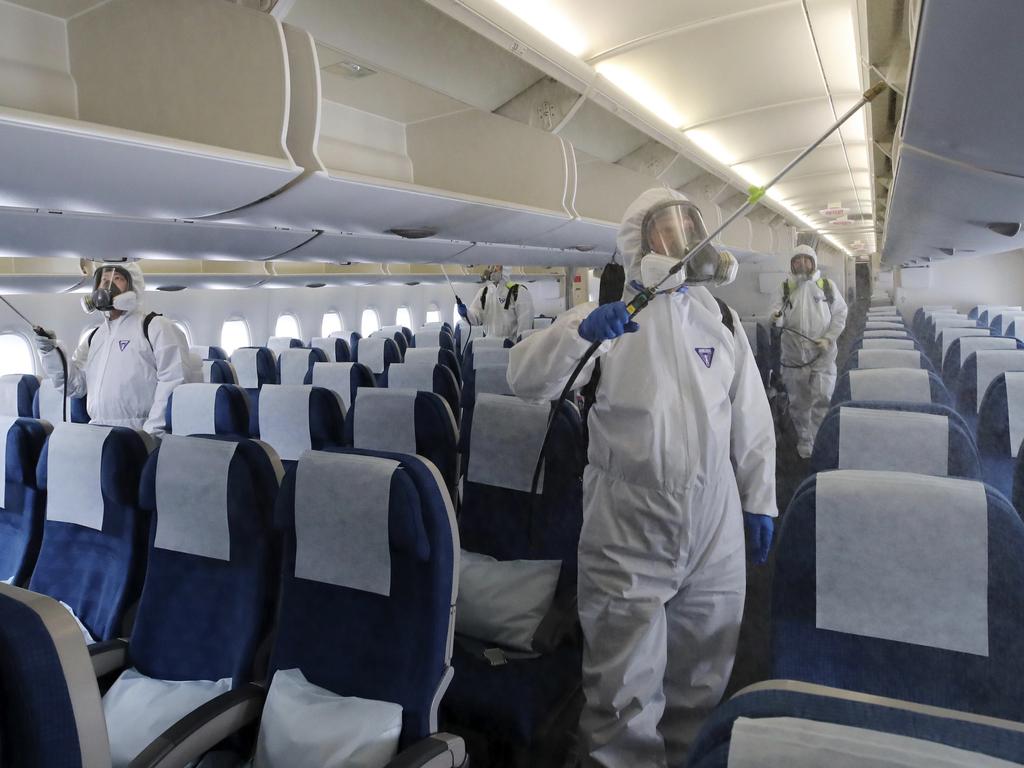 Workers wearing protective gears spray disinfectant inside a plane as a precaution against the new coronavirus at Incheon International Airport in Incheon, South Korea. Picture: Suh Myoung-geon/Yonhap via AP