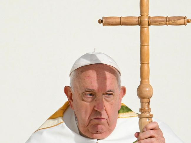 (FILES) A cross casts a shadow on Pope Francis' face as he holds a holy mass at King Baudouin stadium, in Brussels on September 29, 2024. Pope Francis, who has been in hospital for two weeks with double pneumonia, is in a "stable" condition, the Vatican said on March 1, 2025 while again declining to offer a prognosis. (Photo by Alberto PIZZOLI / AFP)