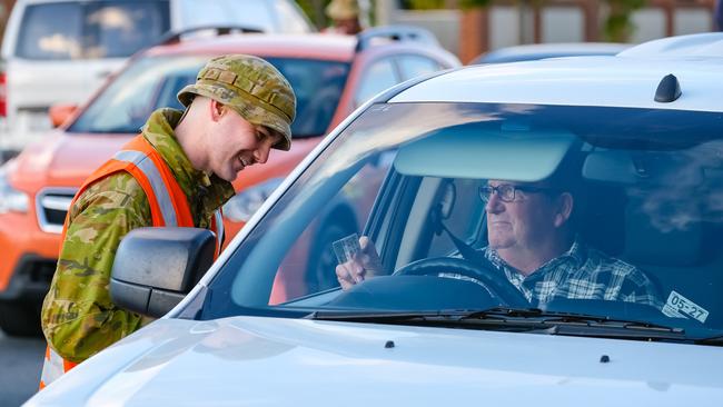 An army officer checks a motorist’s details in Albury on the NSW/Victorian border. Picture: Simon Dallinger