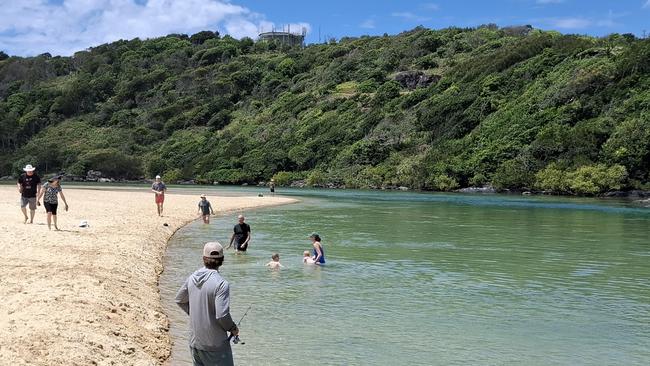 Holiday-makers and locals alike enjoying the beautiful Boambee Beach after the Boambee Creek footbridge reopened.