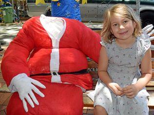 Six year-old Juna Weiss with the headless Santa Claus on Mary St.