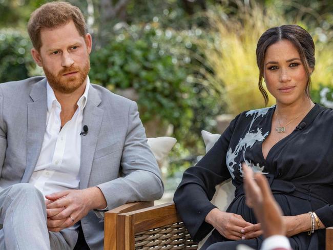 This undated image released March 7, 2021 courtesy of Harpo Productions shows Britain's Prince Harry (L) and his wife Meghan (C), Duchess of Sussex, in a conversation with US television host Oprah Winfrey. - Britain's royal family on March 7, 2021 braced for further revelations from Prince Harry and his American wife, Meghan, as a week of transatlantic claim and counter-claim reaches a climax with the broadcast of their interview with Oprah Winfrey. The two-hour interview with the US TV queen is the biggest royal tell-all since Harry's mother princess Diana detailed her crumbling marriage to his father Prince Charles in 1995. (Photo by Joe PUGLIESE / HARPO PRODUCTIONS / AFP) / RESTRICTED TO EDITORIAL USE - MANDATORY CREDIT "AFP PHOTO/ HARPO PRODUCTIONS -  Joe PUGLIESE" - NO MARKETING NO ADVERTISING CAMPAIGNS - DISTRIBUTED AS A SERVICE TO CLIENTS --- NO ARCHIVE ---