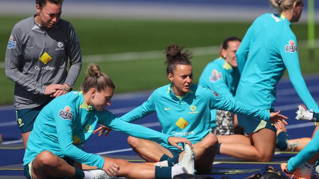 Mackenzie Arnold, Steph Catley and Hayley Raso go through some stretches. Picture: Chris Hyde/Getty Images