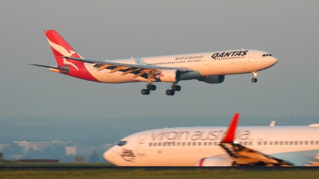 A Qantas Airbus A330-303 plane, registration VH-QPB, coming into land from the south on the main runway of Sydney Kingsford-Smith Airport as flight QF128 from Hong Kong. In the foreground is a Virgin Australia Boeing B737-8FE plane, registration VH-YFZ, taxiing before departure as flight VA1528 to Hobart.  This image was taken from Mill Stream Lookout, Botany Bay on a sunny morning at sunrise on 30 March 2024.27 October 2024Kendall HillPhoto - iStock