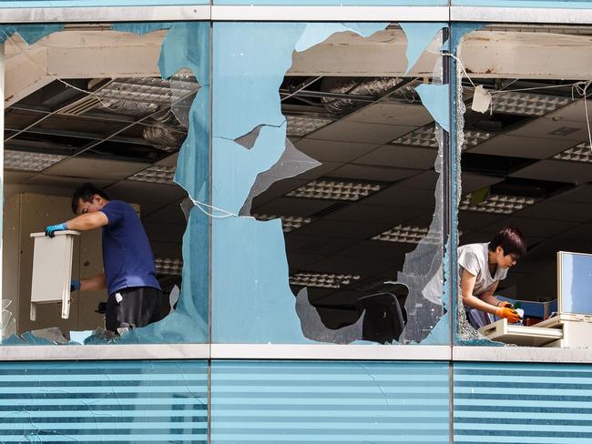 Workers clean a company office, in a harbourside commercial building, whose windows were blown out during Typhoon Mangkhut in Hong Kong. Picture: AFP