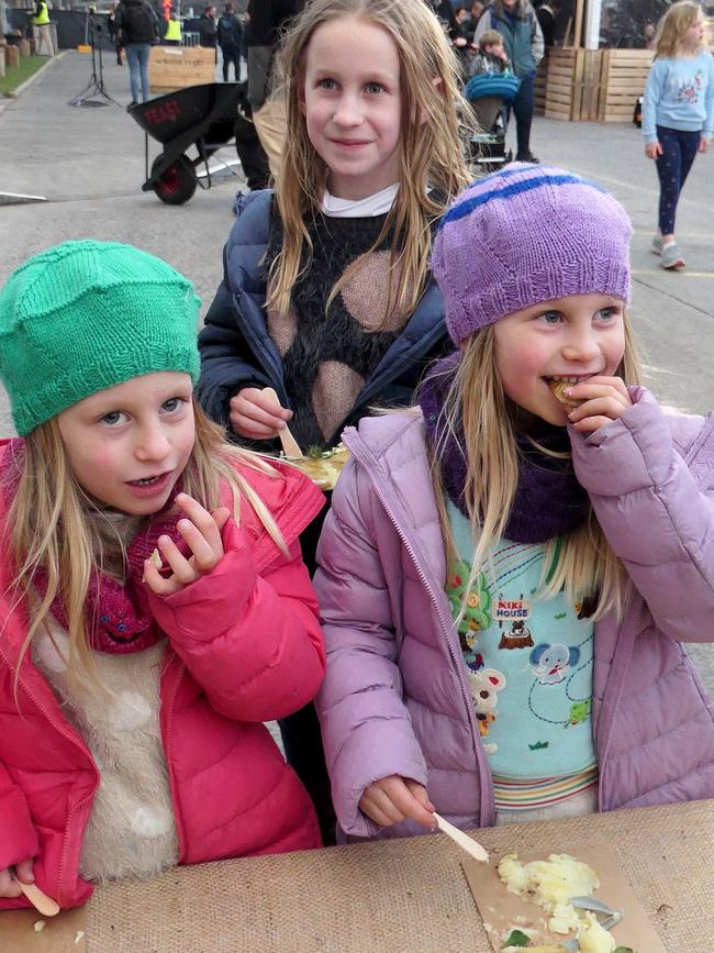 Hobart Winter Feast "Fire and Ice" interactive program for kids. The Mabel Akmentins, 8, and her twin sisters, Nina and Edie, 5, tucking in to the smashed potatoes. Picture: ELAINE REEVES