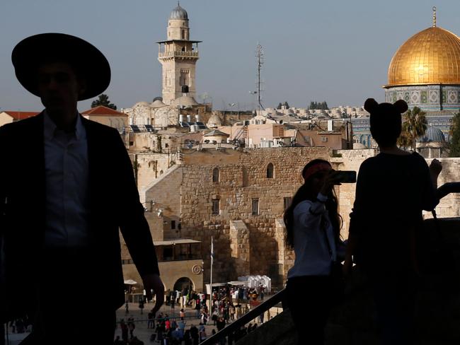 An Ultra-Orthodox Jewish man stands alongside tourists at the Jewish quarter in Jerusalem's Old City overlooking the Dome of the Rock mosque. Picture: AFP