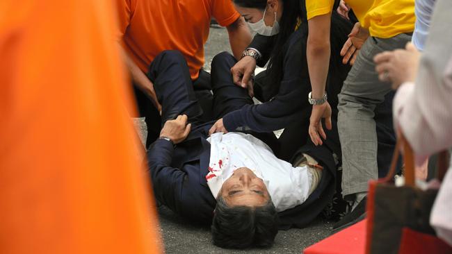 Shinzo Abe lies on the ground after being shot during a speech.