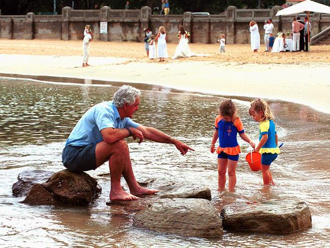 Jim Reid with his nieces, Hannah Reid, 3, and Isabella Pettit, 2, at the spot of a shark attack at Balmoral in 2000. Picture: Virginia Young