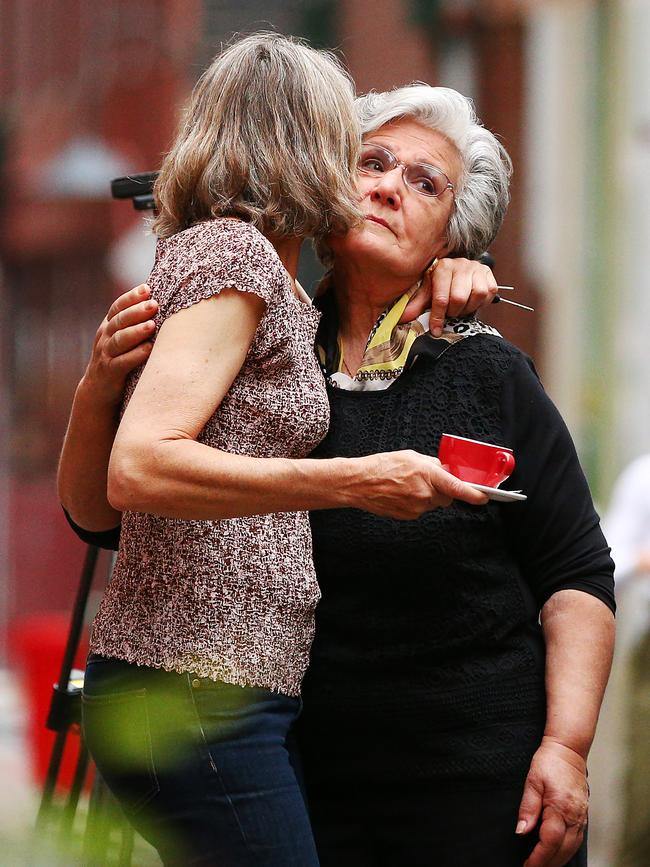 Pellegrini's cake-maker Lucy is hugged on Tuesday morning as the espresso bar reopened to patrons. Picture: Getty Images