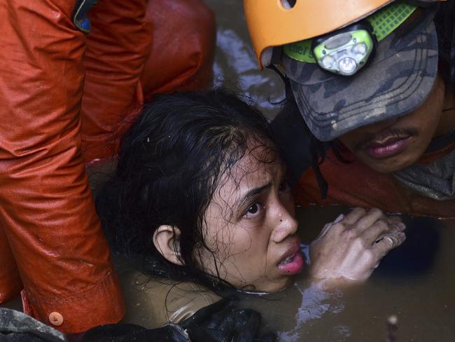 Rescuers try to rescue a 15-year old earthquake victim Nurul Istikharah from her damaged house following earthquakes and tsunami in Palu, Central Sulawesi, Indonesia, Sunday, Sept. 30, 2018. Rescuers were scrambling Sunday to try to find trapped victims in collapsed buildings where voices could be heard screaming for help after a massive earthquake in Indonesia spawned a deadly tsunami two days ago. (AP Photo/Arimacs Wilander)