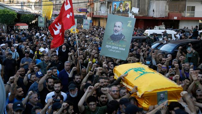 Mourners carry the flag-draped coffin of Mohammed Srur, Hezbollah's head of the drone unit, killed a day earlier in an Israeli strike in Beirut's southern suburbs, during his funeral with two other slain Hezbollah members on September 27, 2024. Picture: STR / AFP