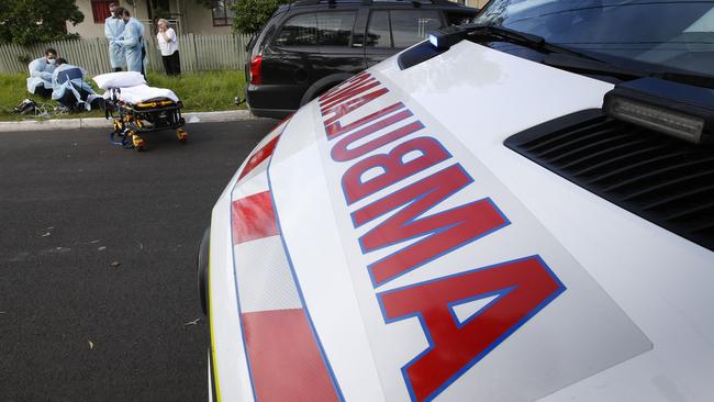 Ambulance Victoria paramedics work on a young woman by the side of the road for a suspected drug overdose. Picture: David Caird