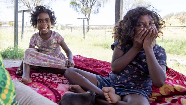 Tilana and Monica smile from their great-grandmother’s home on the outskirts of Alice Springs. Picture: Liam Mendes