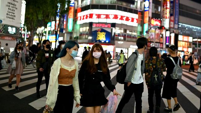 People wearing face masks cross a street in Tokyo’s Shinjuku area. A Japanese team claims its ‘piezoelectric fabric’ can resist virus and bacteria. Picture: AFP