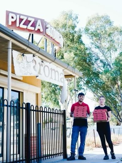 Two Aroma Pizza House employees, Benkil and Jade, with some of the food ordered during a prank and donated to Puddle Jumpers.