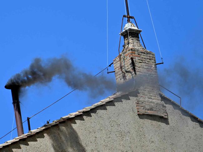 This photograph shows black smoke rising from the chimney of the Sistine Chapel signalling that cardinals failed to elect a new pope during their conclave in the Vatican on May 8, 2025. (Photo by Alberto PIZZOLI / AFP)