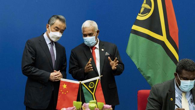 Vanuatu's Prime Minister Bob Loughman Weibur (C) talks to visiting Chinese Foreign Minister Wang Yi during a signing ceremony of agreements between the two countries. Picture: AFP.