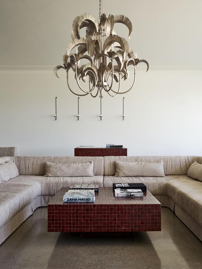 The hotel’s design injects dramatic flourishes such as this chandelier into monochromatic spaces. Picture: Mark Roper