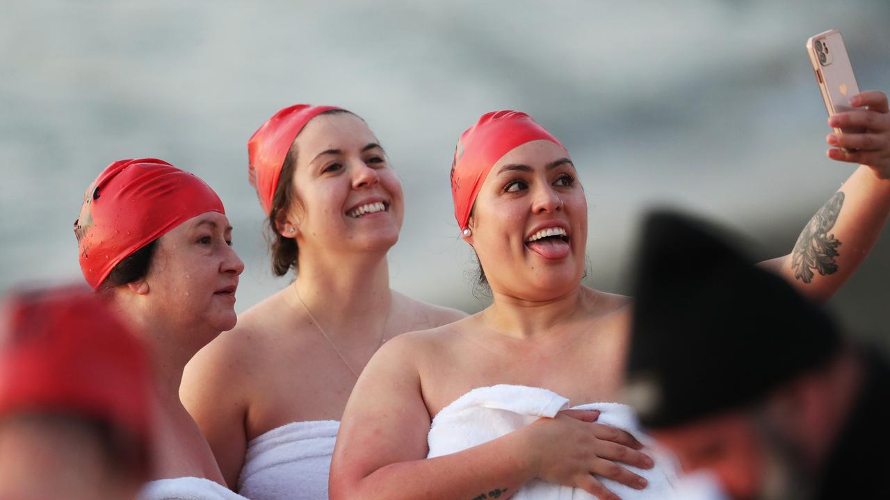 Participants taking selfies on the beach after the swim. Nude Solstice swim as part of Dark Mofo 2021 at Long Beach Sandy Bay. Picture: Nikki Davis-Jones