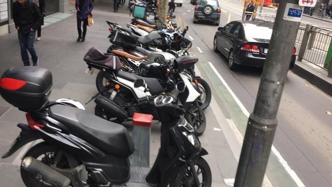 Motorcycles parked on footpaths in Melbourne's CBD. 