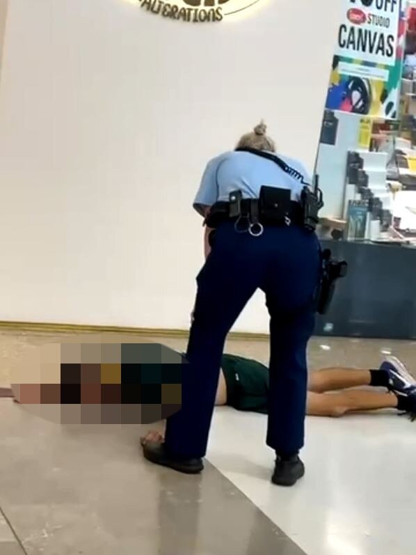 The female police officer stands over the assailant after he was shot and killed.