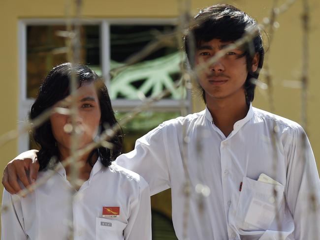 Good news ... Myanmar students, Myo Htet Paing, 20, (L) second year in physics, Lwin Ko Ko Aung, 20, (R) tenth grade, pose behind a barbed wire fence outside the courthouse in Tharrawady town. Picture: AFP