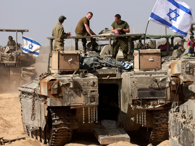 Israeli soldiers stand atop a tank near the border with the Gaza Strip, amid the ongoing conflict between Israel and the Palestinian Hamas movement. Picture: AFP