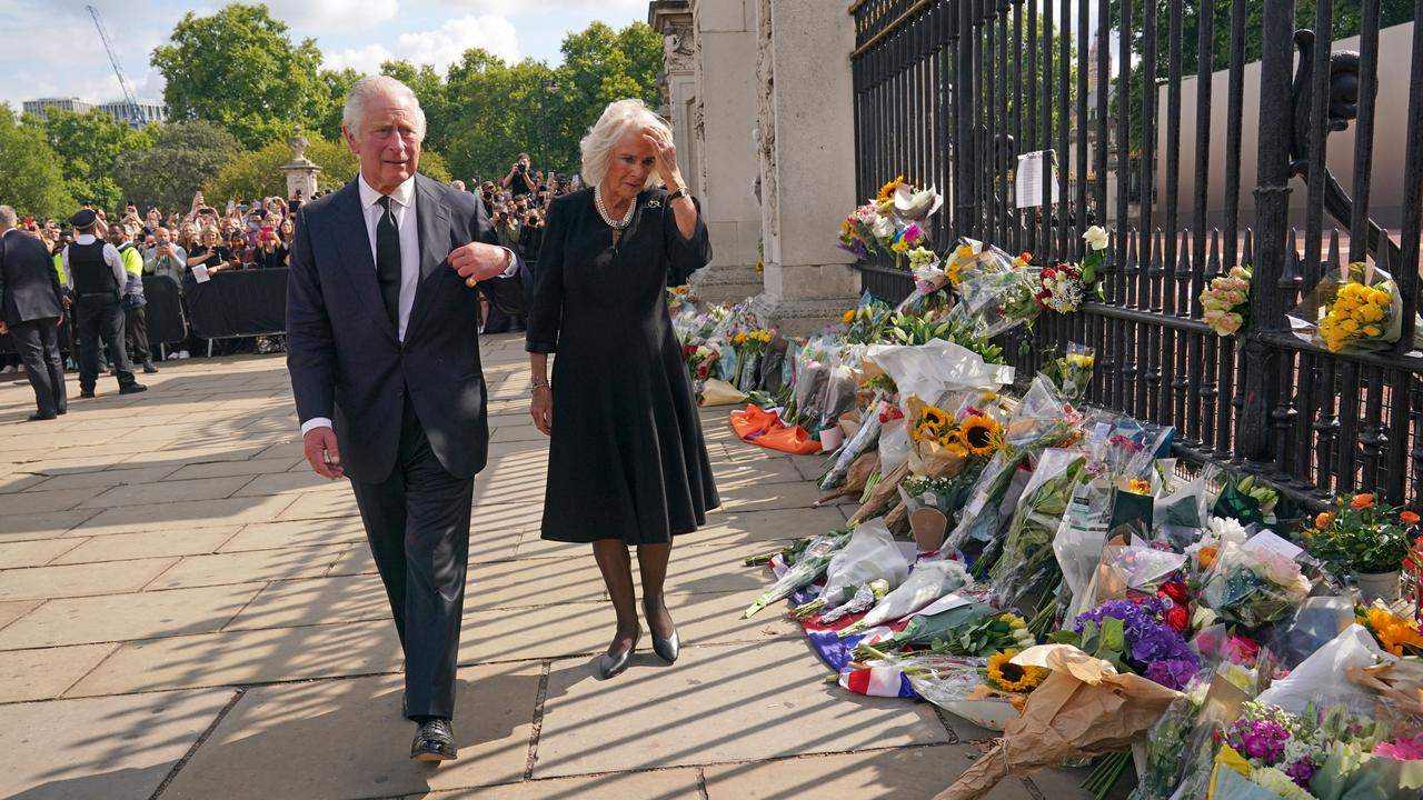 Britain's King Charles III and Britain's Camilla, Queen Consort view floral tributes upon their arrival Buckingham Palace. Picture: Getty Images.