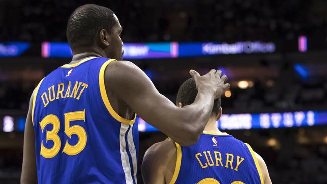 Golden State Warriors' Kevin Durant, left, pats Stephen Curry, right.