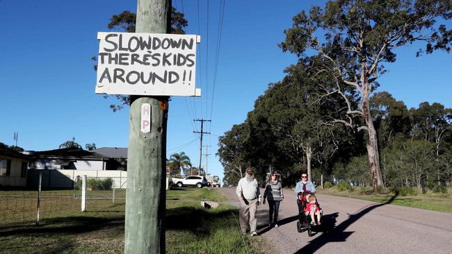 Taleiha Hobson-Rozyn with her children Jasper and Jai and Tony and Denise Grant Ttrying to negotiate their stret with no footpaths.(AAP Image/Sue Graham)