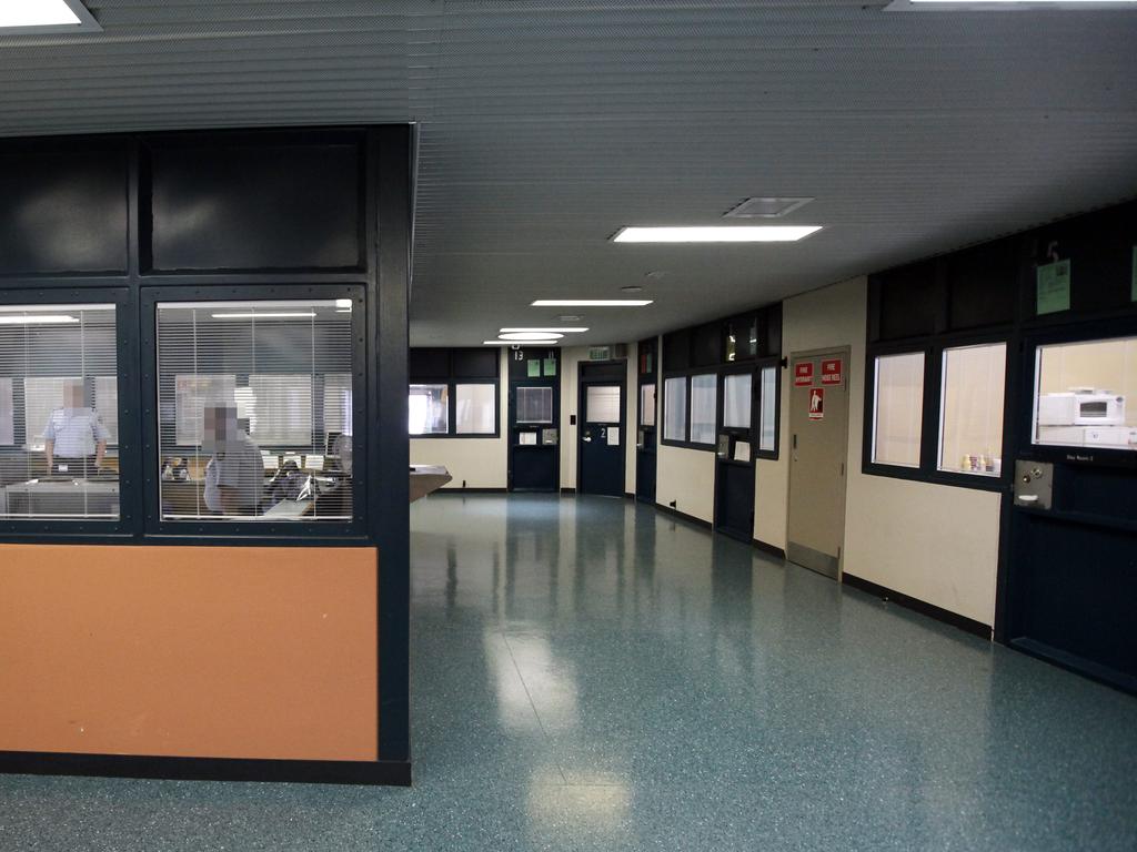 Inside the creepy, clinical confines of Supermax prison with rows of day rooms and cells behind.