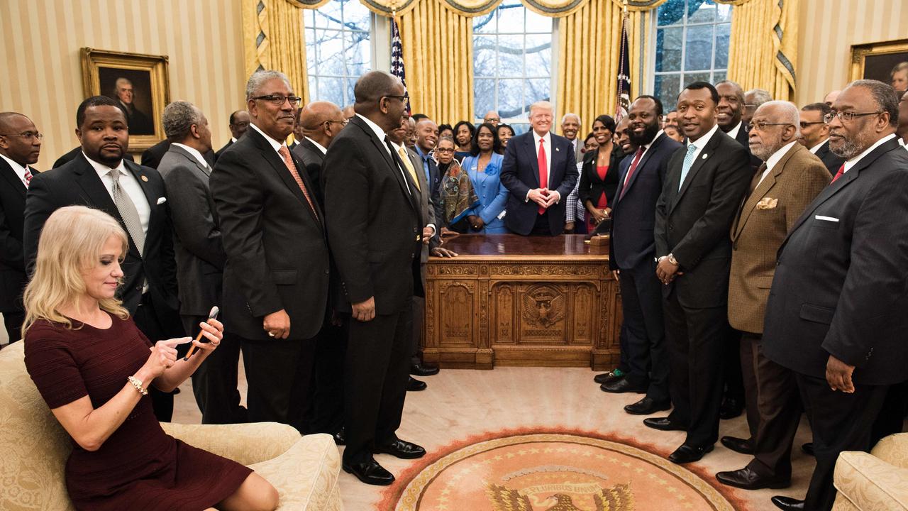 Conway checks her phone after taking a photo as US President Donald Trump and leaders of historically black universities and colleges pose for a group photo in the Oval Office of the White House, on February 27, 2017 in Washington. Picture: AFP