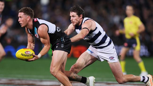 Kane Farrell is about to be tackled by Isaac Smith. Picture: James Elsby/AFL Photos via Getty Images