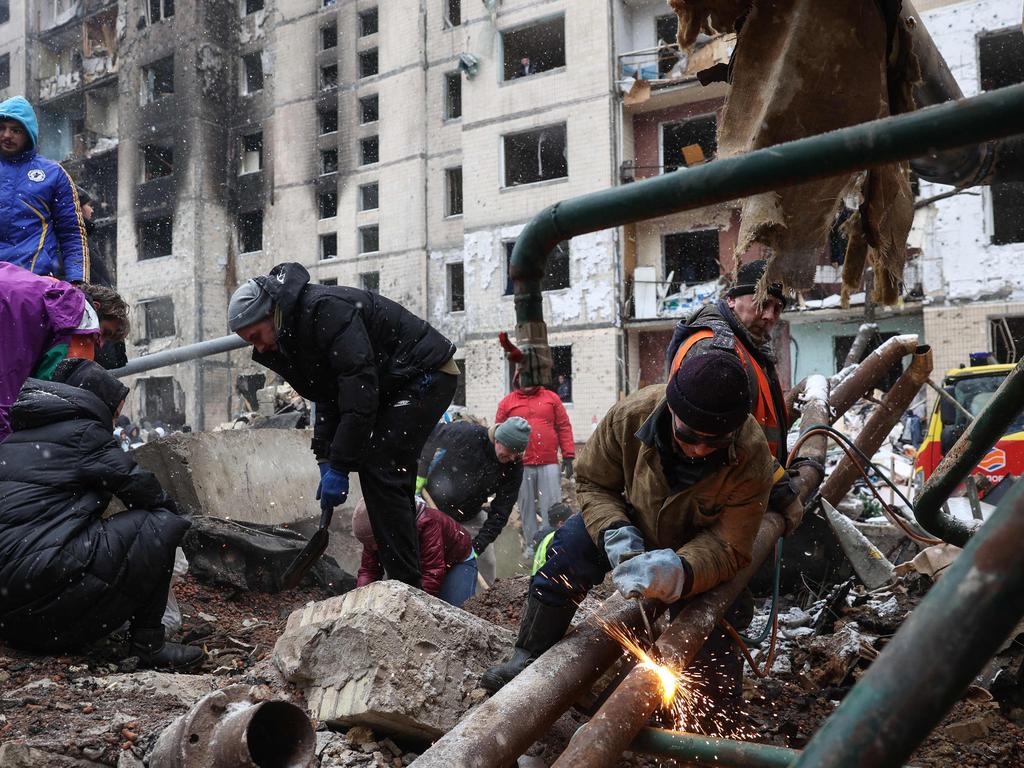 Volunteers work to clear rubble outside a high-rise building destroyed following a Russian missile attack in central Kyiv, on January 3. Picture: Anatolii STEPANOV / AFP